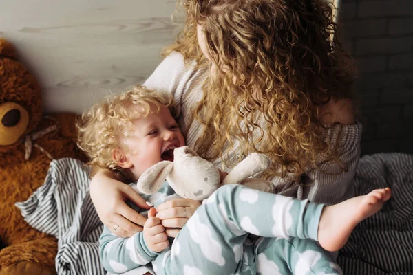 Friendly family, young curly mother playing with her little son, laughing — Stock Photo, Image