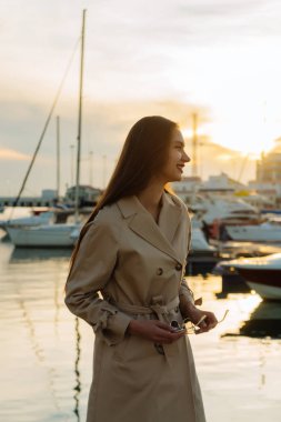 deniz manzarayı bej bir palto lüks güzel uzun saçlı kız gülümseyerek