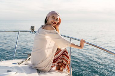 akşam güneş ışınlarının onun yatta bir tatil mutlu genç kız trendy yaz pantolonlu hoşlanır