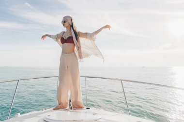 Lüks bir kadın şık yaz giysileri aittir ve güneş onun yatta rahatlatır