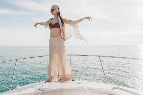 A luxus elegáns lány élvezi a meleg tengeri levegőt egy jachton fehér nyári ruhák — Stock Fotó