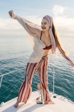 Modern giyimleri şık mutlu kız bir tatil bir yatta sahiptir, Karayip Denizi üzerinde yelken