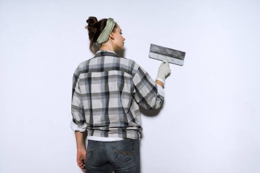 duvarlar bir spatula ile tesviye ekose gömlekli genç ince kız