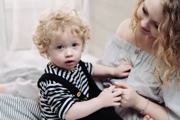 Caring curly mom spends time with her young son, a friendly family — Stock Photo, Image