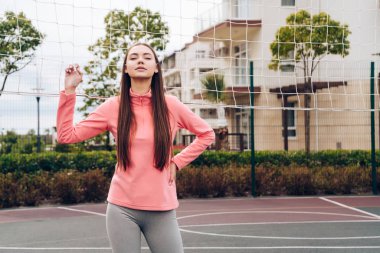 kendine güvenen güzel kız bir voleybol net bir spor zemin üzerinde karşı poz pembe ceket