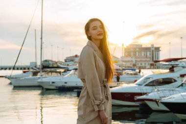 Lüks uzun saçlı kadın onun Yat Limanı, günbatımında poz bekliyor
