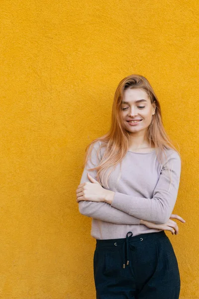 Elegante chica encantadora modelo rubio en ropa de moda posando sobre fondo amarillo — Foto de Stock