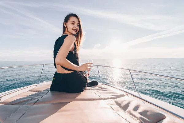 Прекрасная красивая девушка, плывущая по Карибскому морю, пьющая шампанское и улыбающаяся — стоковое фото