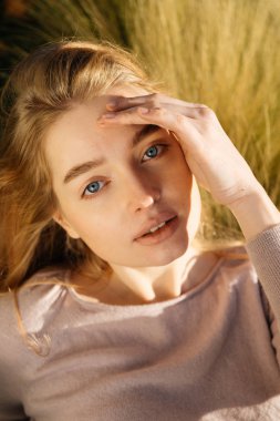 Güneş ve pozlar çim güzel kız sarışın mavi gözlü modeli yatıyor