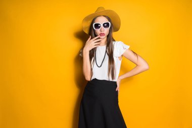 emin uzun saçlı kız modeli şık şapka sarı bir arka plan üzerinde poz içinde
