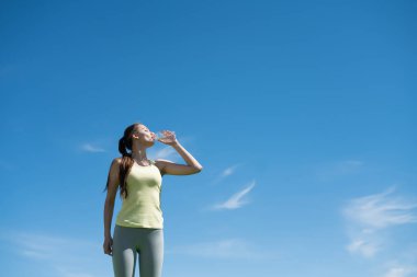 ince atletik kız hevesle açık havada zor bir çalışmadan sonra suyu içer