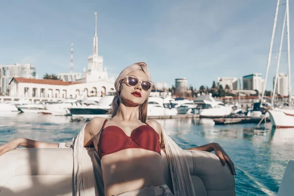 a luxurious rich woman in sunglasses enjoys relaxing on a yacht, vacations