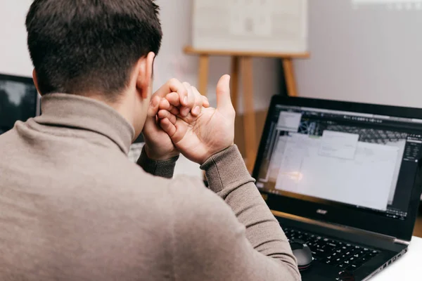 Jovem designer gráfico masculino trabalhando no escritório no laptop — Fotografia de Stock