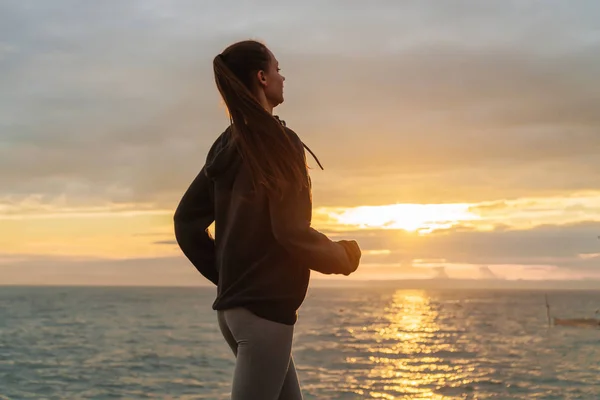 Veloce sport ragazza jogging al tramonto sul mare, vuole perdere peso — Foto Stock