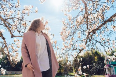 parkta yürüyen şık kıvırcık kadın sıcak güneşli gün