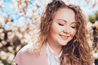 sevimli kıvırcık saçlı kadın dinlenme ve parkta yürüyüş, gülüyor