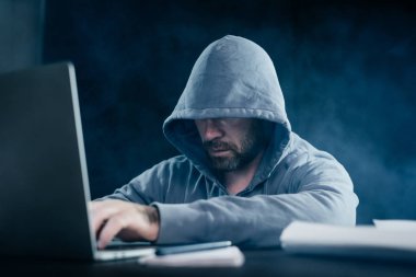 Karanlıkta bir dizüstü bilgisayarda yasadışı bir şey yapıyor bir sakallı gizemli adam