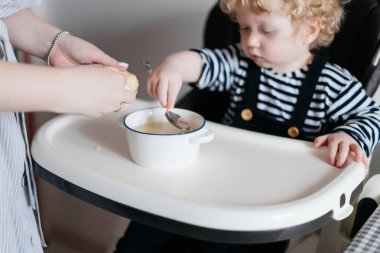 bakım genç bir anne onu genç oğlu ile lezzetli bir çorba, beslemeleri bir aile akşam yemeği