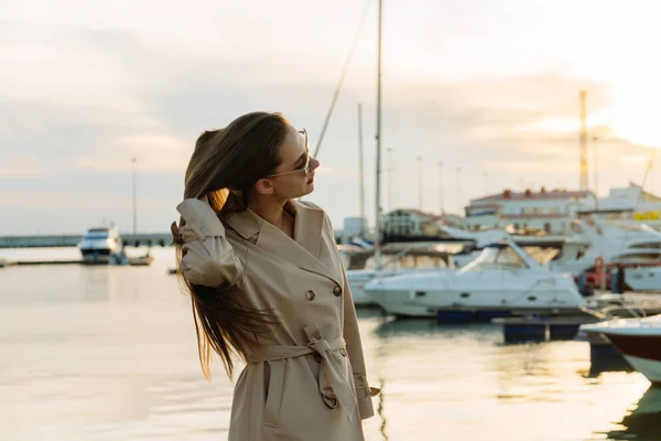 Una giovane donna con bei capelli spessi gode di caldo clima estivo, si trova nel porto marittimo — Foto Stock