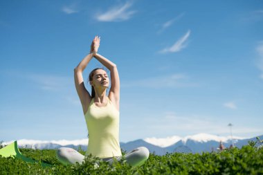 yeşil çimenlerin üzerinde bir parkta yoga yapan düzgün güzel kız hoşlanır güneş