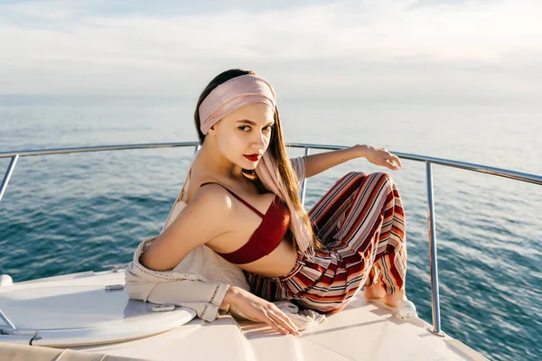 Rahatlatıcı, tatil şık elbiseleri deniz karşı bir yatta poz lüks güzel kız — Stok fotoğraf