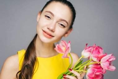 temiz cilt olan güzel kadın güzel kokulu çiçekler, bir buket gülümseyen ve kameraya bakıyor tutar