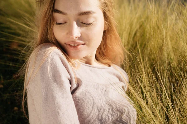 Encantadora chica joven rubia descansando y disfrutando del calor en la hierba en el sol — Foto de Stock