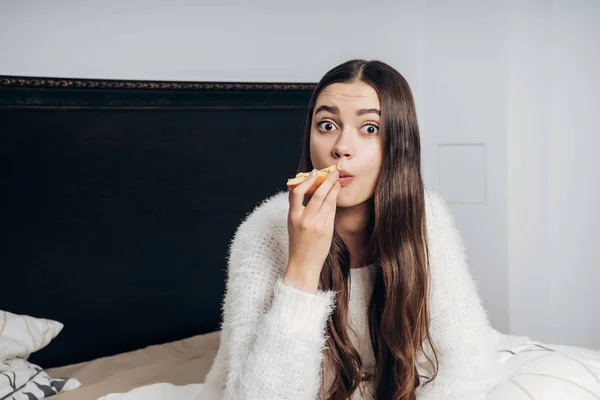 Belle fille surprise assis dans le lit tôt le matin manger une pomme utile — Photo