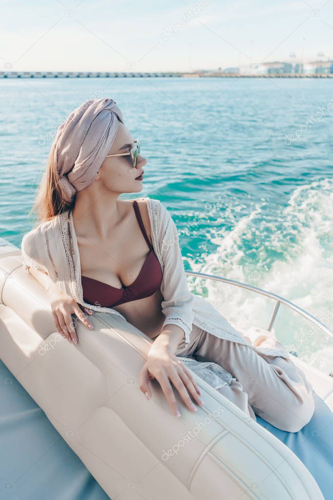 a luxurious sexy girl sails on the blue sea, enjoys a vacation