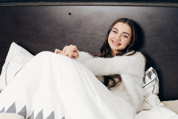 Bonito sorrindo menina encontra-se na cama no início da manhã, não quer se levantar — Fotografia de Stock