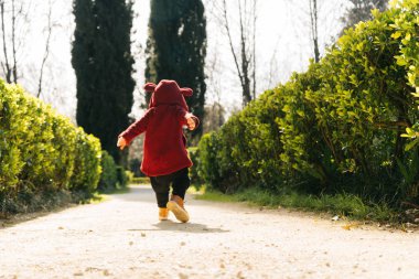 sevimli bir çocuk takım elbiseli küçük bir çocuk öğleden sonra güneş ışınlarının parkta yürüyor