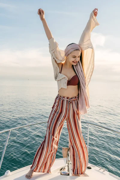 Menina elegante feliz está satisfeito com as férias tão esperadas, levantou as mãos para cima, no iate — Fotografia de Stock