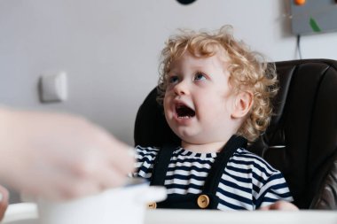 Mutfakta, lezzetli çorba besleme anne oturan küçük kıvırcık bebek çocuk