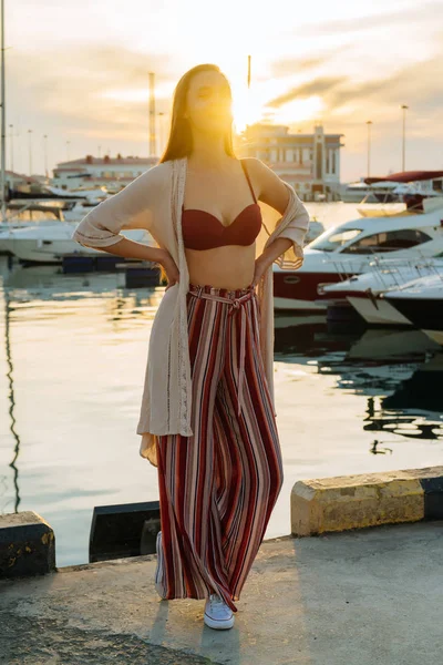 Long-haired Dziewczyna w lato stylowe ubrania pozowanie w morskim na zachód, letnie wakacje — Zdjęcie stockowe