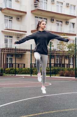 Etkin atletik kız açık havada, atlama, kardiyo egzersiz egzersiz