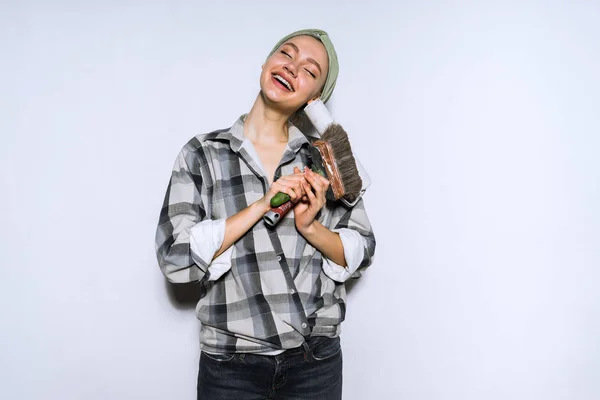 Niña feliz haciendo reparaciones en su nuevo apartamento, sosteniendo pincel para pintar paredes en las manos — Foto de Stock