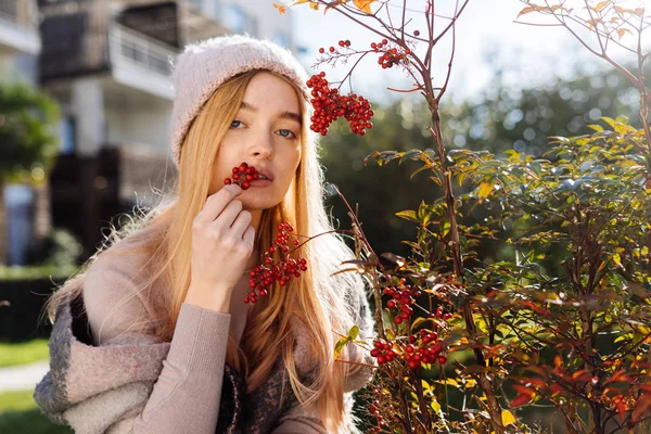 Mooi blonde meisje in een roze hoed genieten van natuur en warmte in haar tuin — Stockfoto