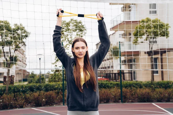 Vertrouwen slanke meisje doet oefeningen voor handen op het sportveld, leidt een actieve levensstijl — Stockfoto