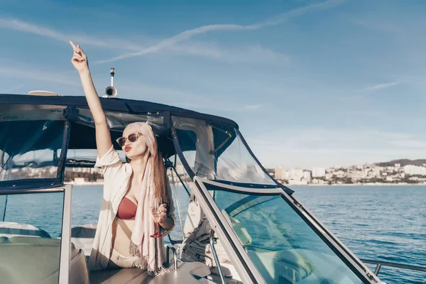 Ein wunderschönes schwules Mädchen mit Sonnenbrille schwimmt auf ihrer Jacht durch die Karibik, trinkt Champagner — Stockfoto