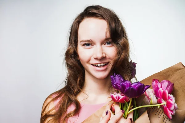 En lyxig ung kvinna håller en bukett doftande blommor och poserar — Stockfoto