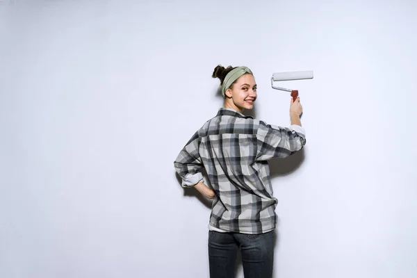 롤러와 흰색에서 벽 그림 격자 무늬 셔츠에 활성 웃는 소녀 — 스톡 사진