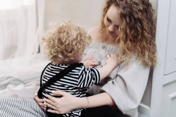 Curly, caring young mother playing with her little son, having fun together — Stock Photo, Image