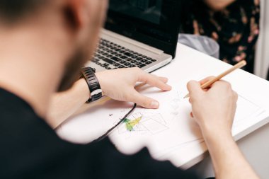 Ofiste bir proje üzerinde siyah kazak erkek grafik tasarımcı odaklı