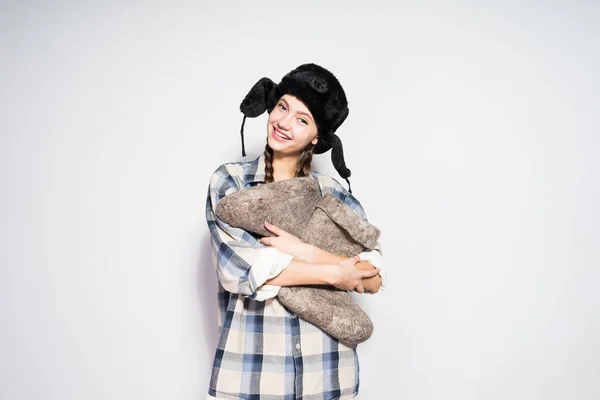 Charmantes russisches Mädchen mit Zöpfen hält warme graue Stiefel in den Händen, freut sich im Winter — Stockfoto