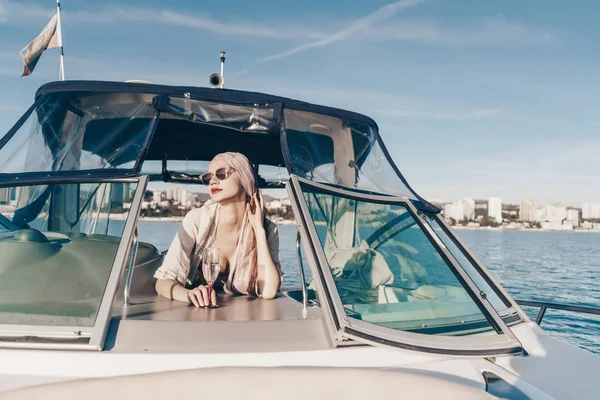 A luxurious young woman in sunglasses enjoys relaxing on a yacht, sails on the Caribbean sea — Stock Photo, Image