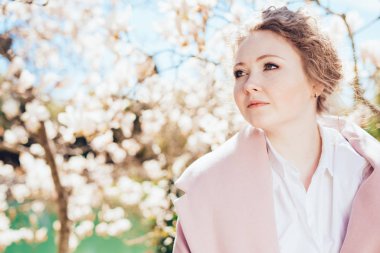 sıcaklık ve güneş Park zevk, poz pembe bir ceket güzel büyüleyici kadın