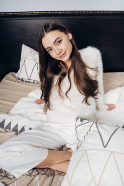 güzel uzun saçlı kız beyaz pijama yatağa zor bir günden sonra dinlenme
