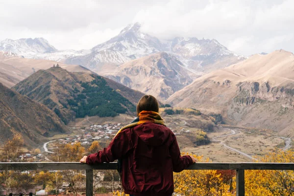 a young girl in a jacket enjoys the mountain nature and clean air, loves to travel