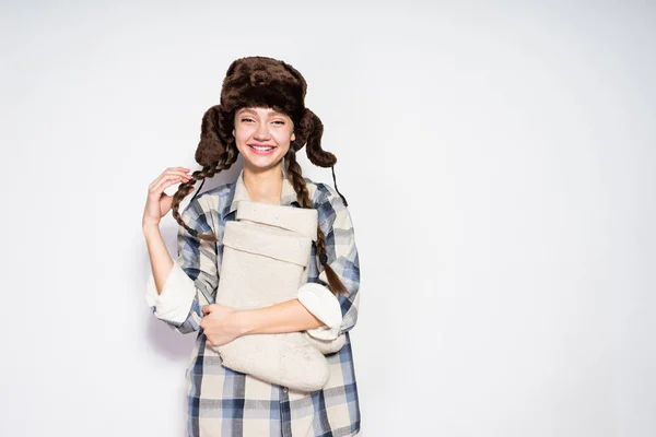 Vrolijke jonge Russische meisje met pigtails wachten voor de winter, het dragen van een hoed warme bont, glimlachend — Stockfoto