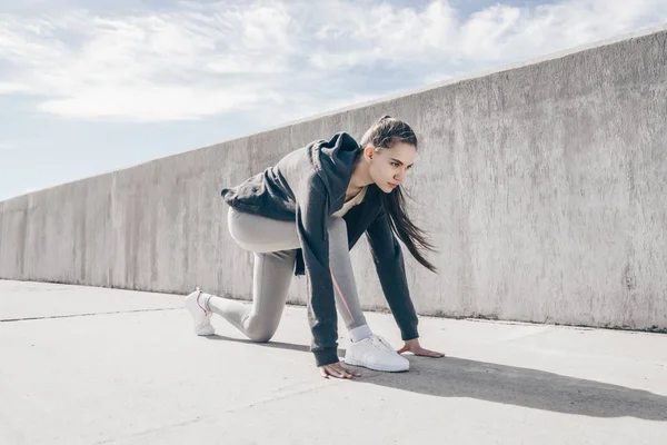 Persistent sport meisje in een grijze jas bereid te lopen van een marathon, klaar voor wedstrijden — Stockfoto